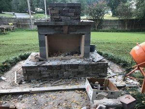 DIY outdoor fireplace backyard patio veneer construction cement mixer hearth chimney grass fence firebrick cornerstone