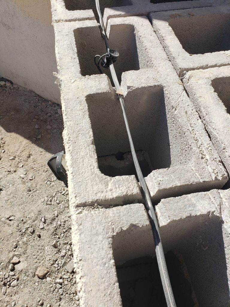 Low voltage lighting cord in a DIY outdoor fireplace. LED lighting and cinder block