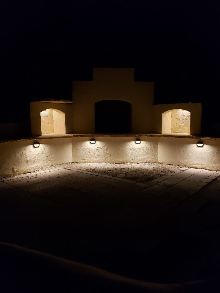 Outdoor lighting on DIY outdoor fireplace at night