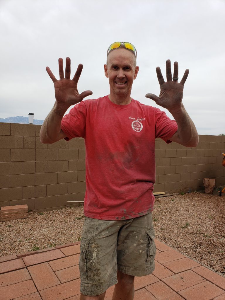 Man pouring concrete for outdoor fireplace