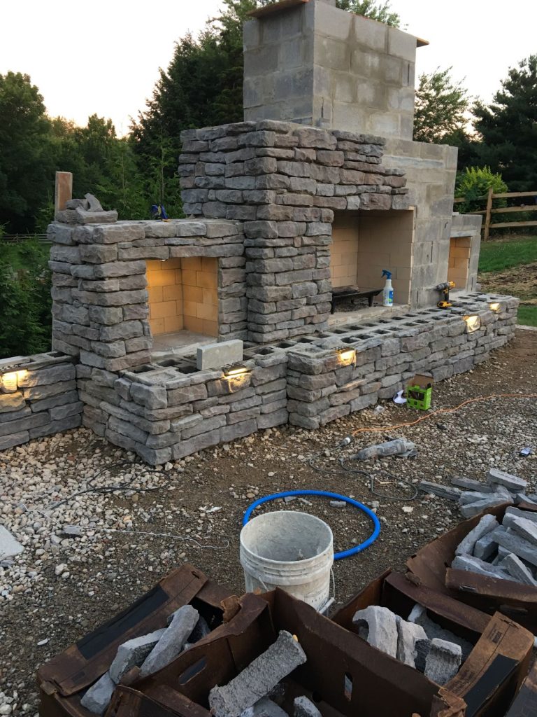 Masonry construction outdoor fireplace with storage and concrete lintels